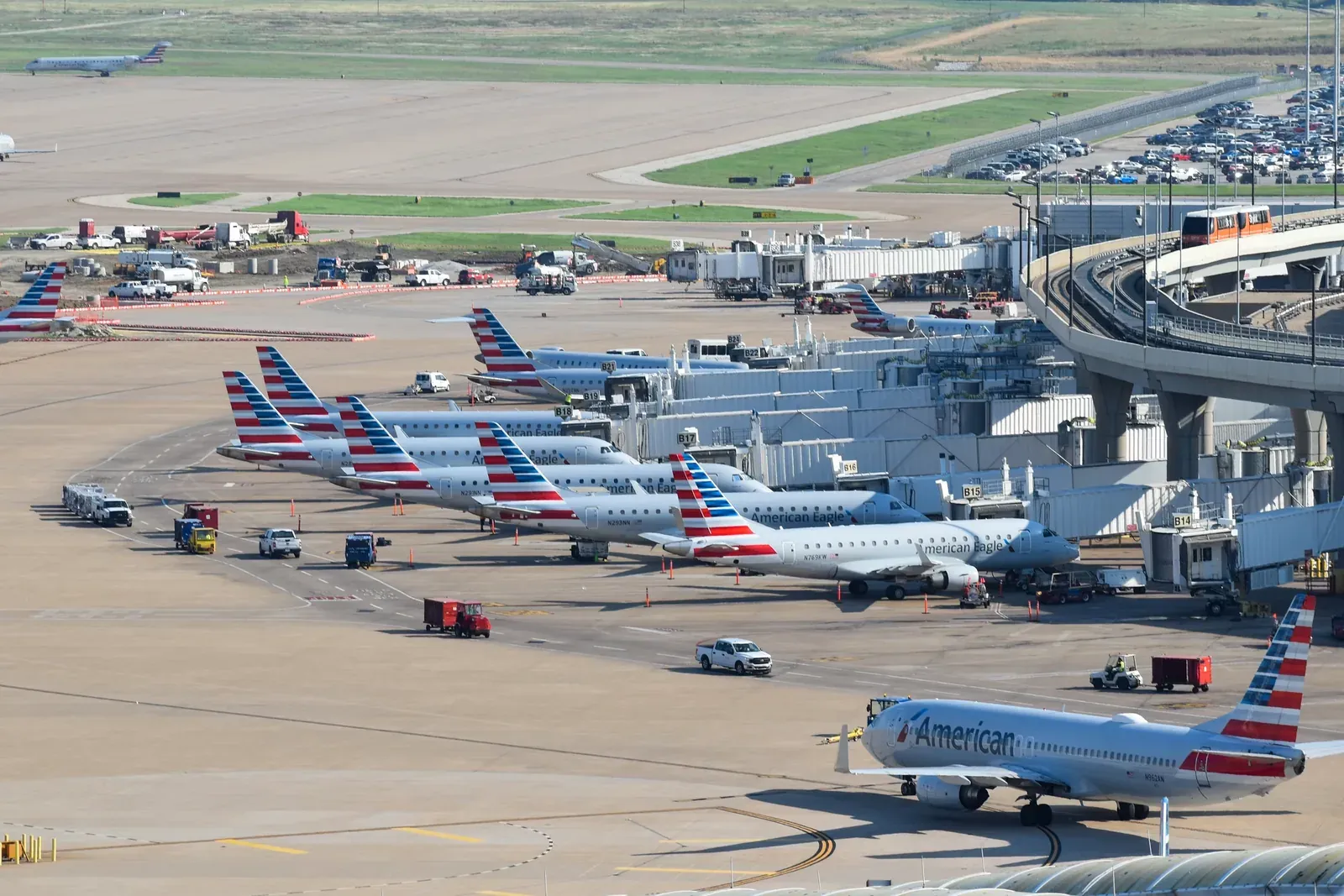 Airliners from several carriers parked across an airport apron, seen from above.