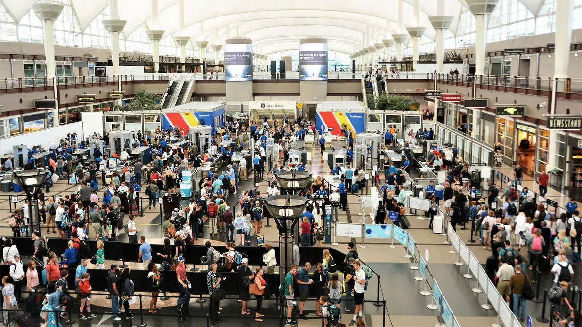 A traveller facing a crowded airport departure board.